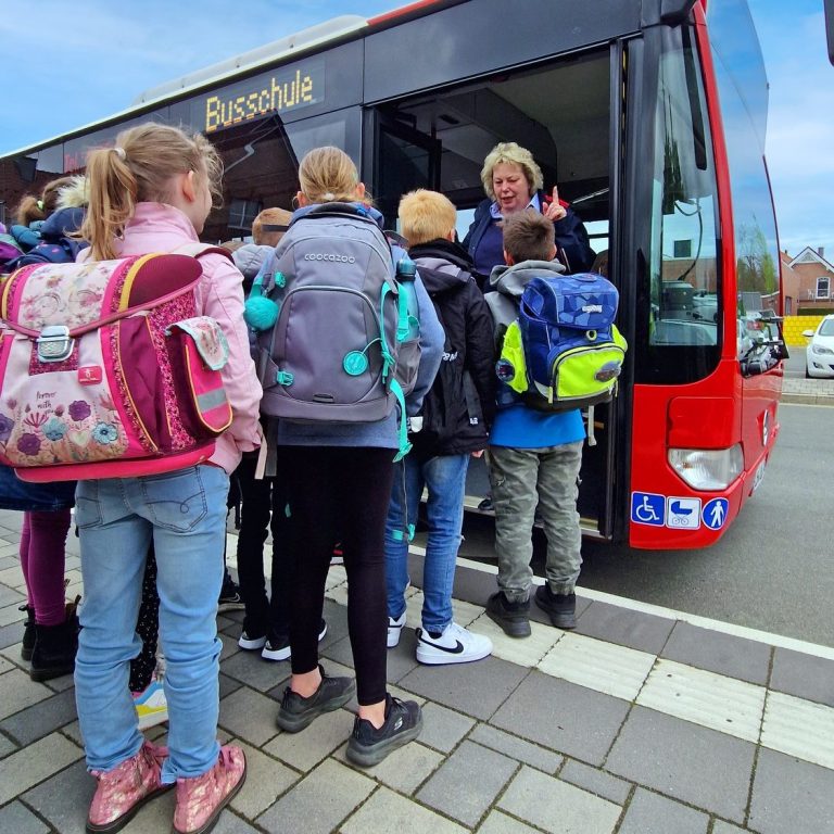 Quelle: Regionalverkehr Münsterland GmbH Kinder, die vor einem Linienbus stehen und an dem Format "Busschule" teilnehmen.